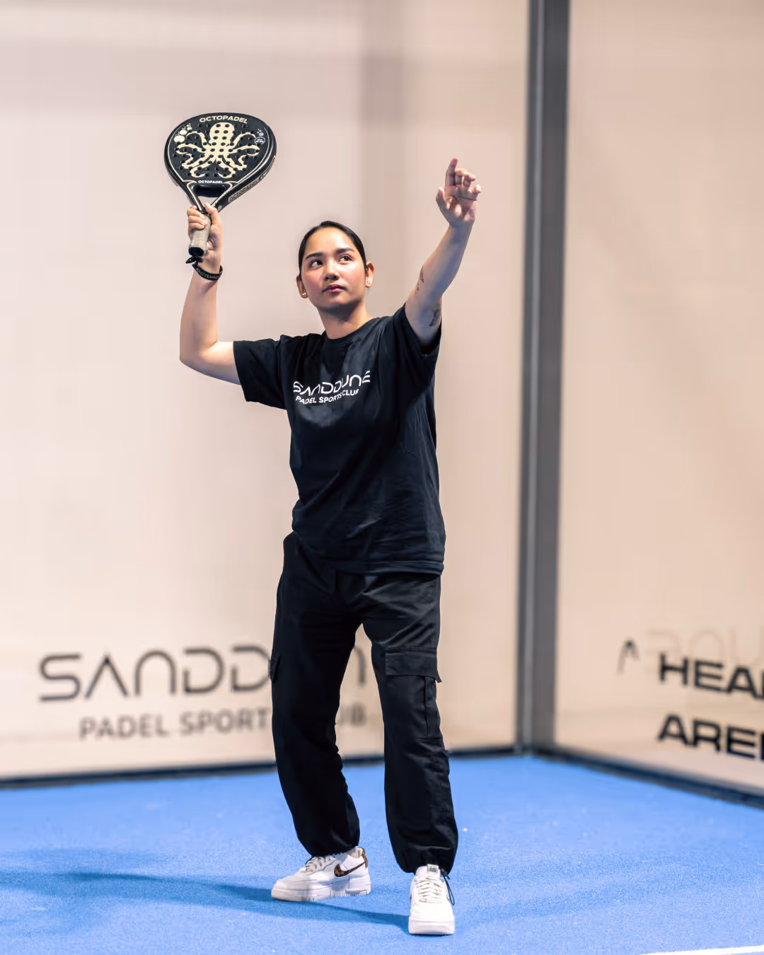 A women padel player ready to smash the padel ball on the court