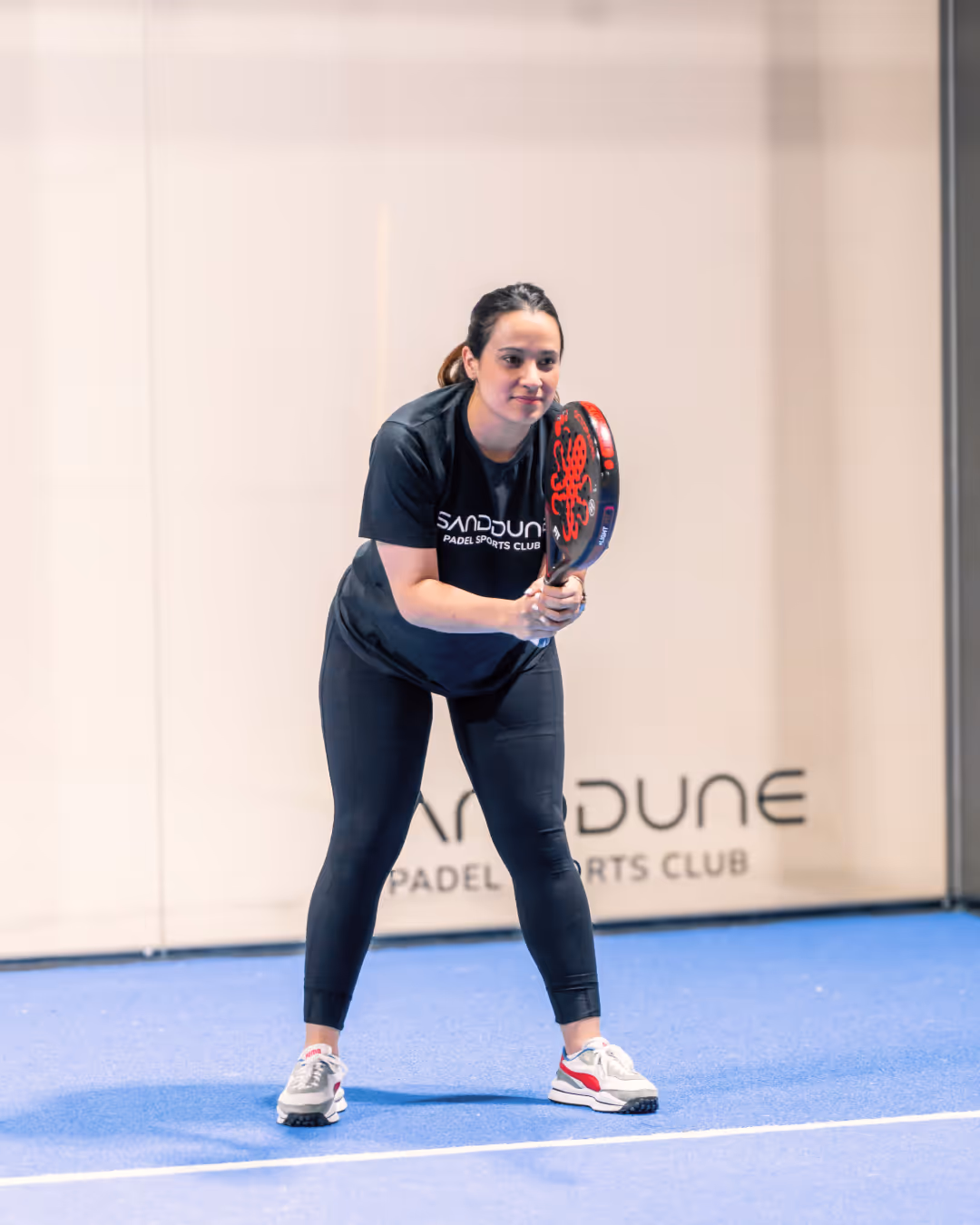 A beginner women padel player ready to receive a serve
