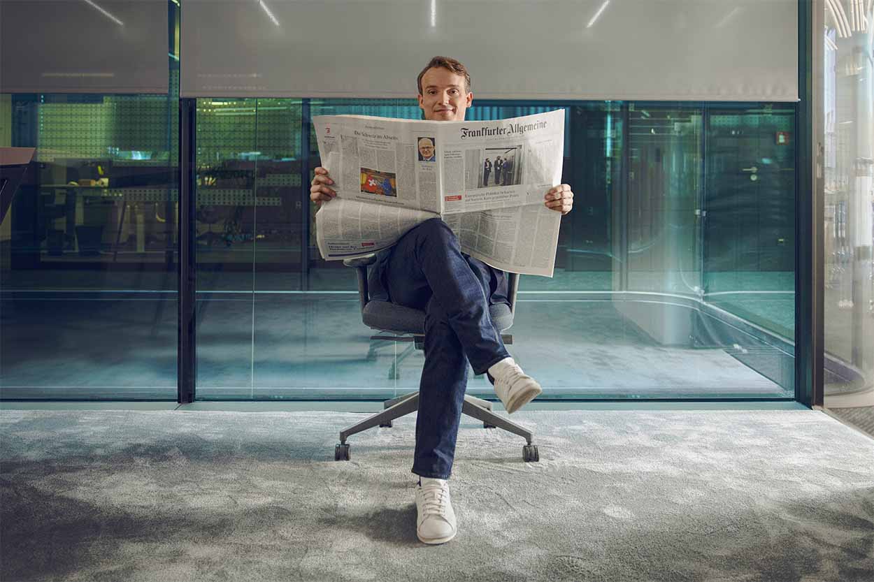 A hand holding the Tagesspiegel im Queerformat like a flag