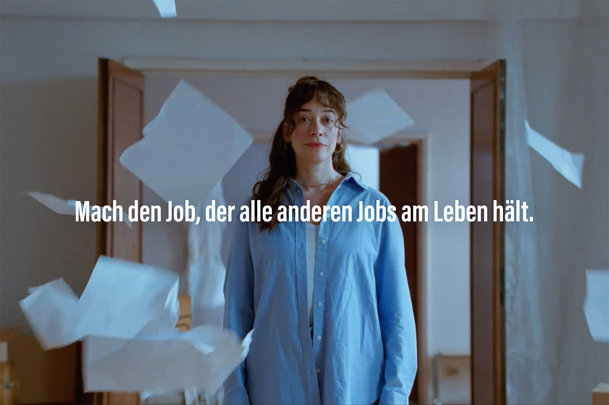 A hand holding the Tagesspiegel im Queerformat like a flag