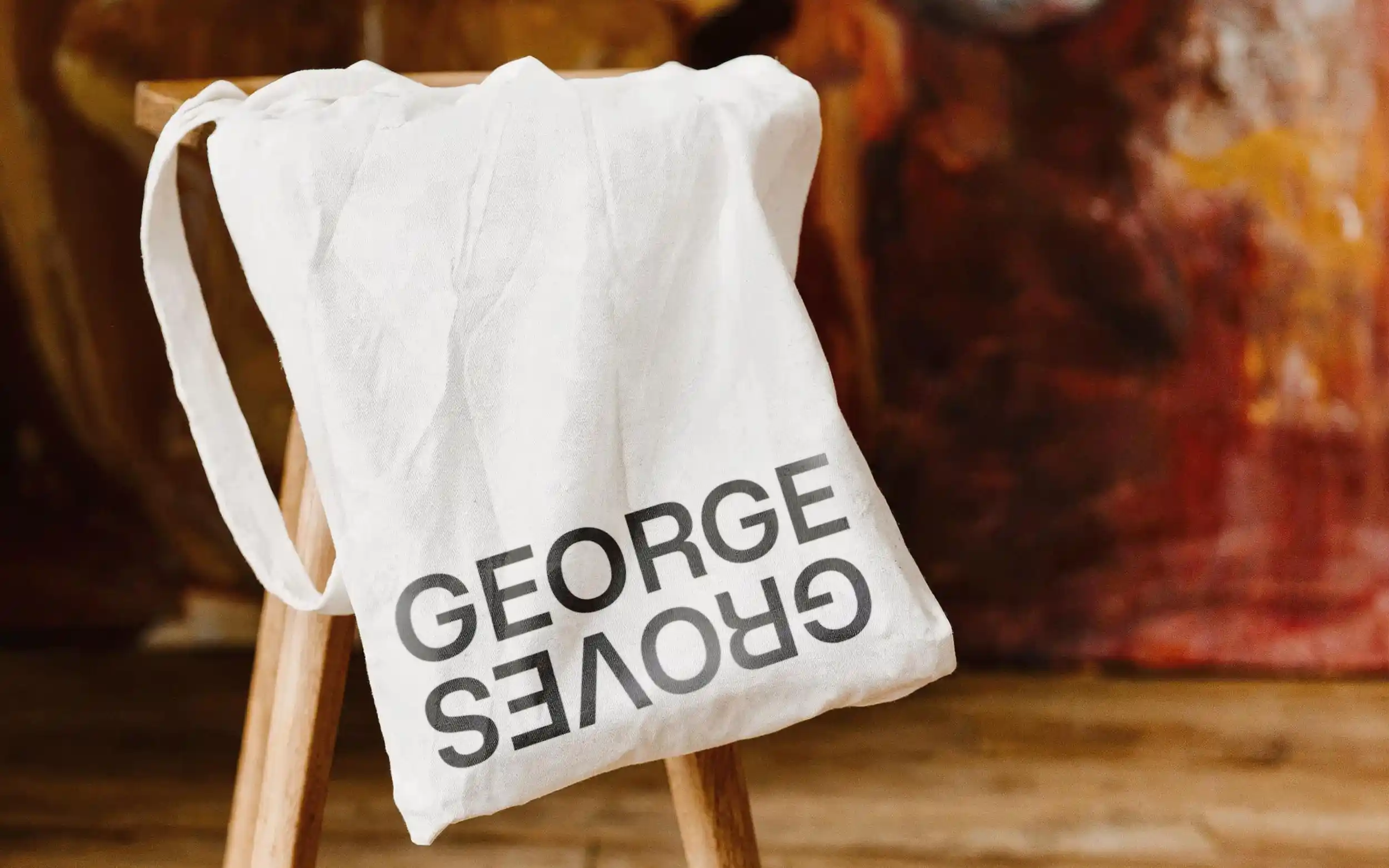 Canvas tote bag draped over a stool displaying 'George Groves' branding.
