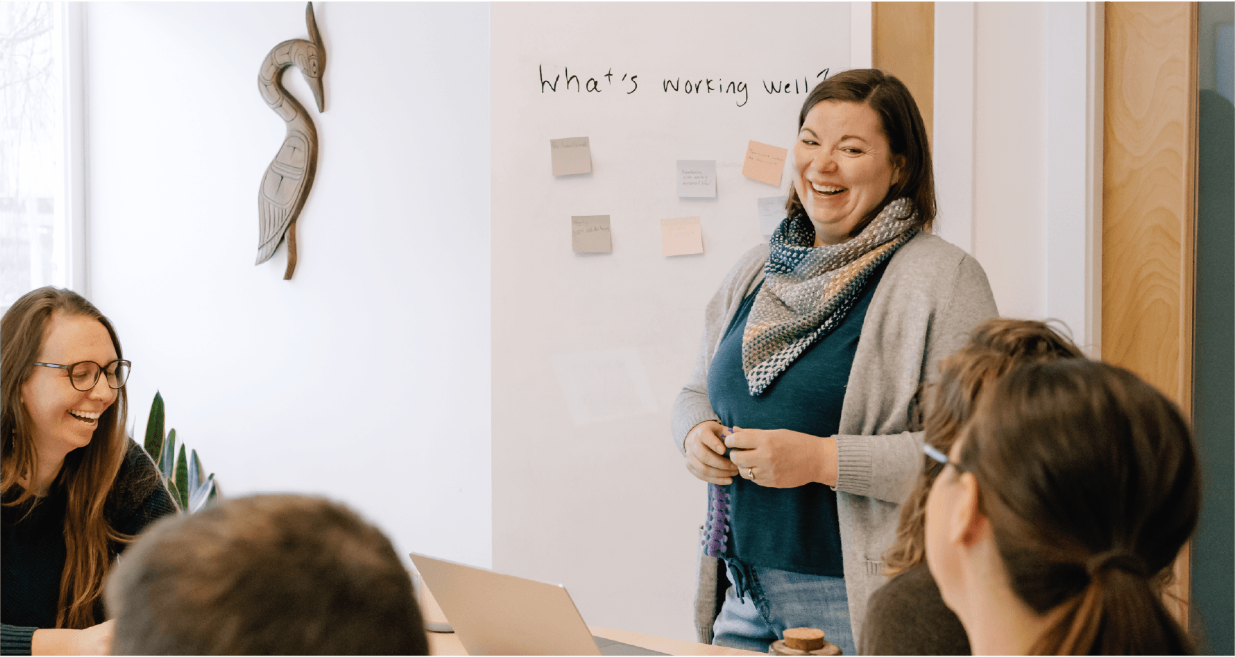 Lea Pigage standing at head of board room table teaching workshops