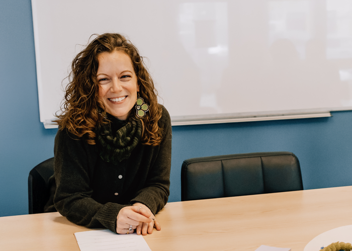 woman laughing while sitting at boardroom table
