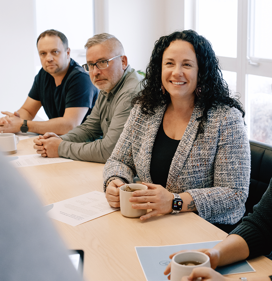 woman sitting in workshop smiling and drinking coffee