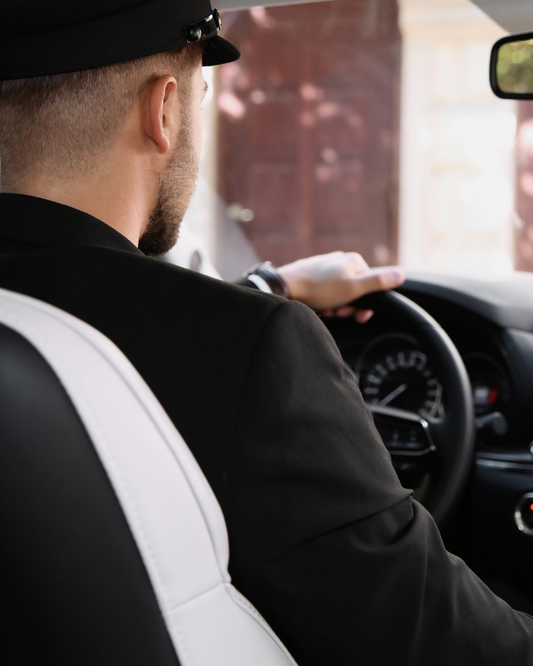 Modern, open-air room with floor-to-ceiling windows overlooking a calm ocean.   Wooden lounge chairs facing the water, with tall grasses near the edge.