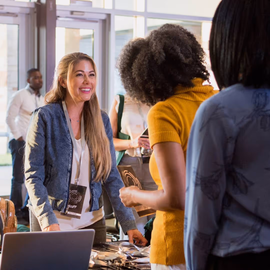 Woman smiling at person in line at an event table