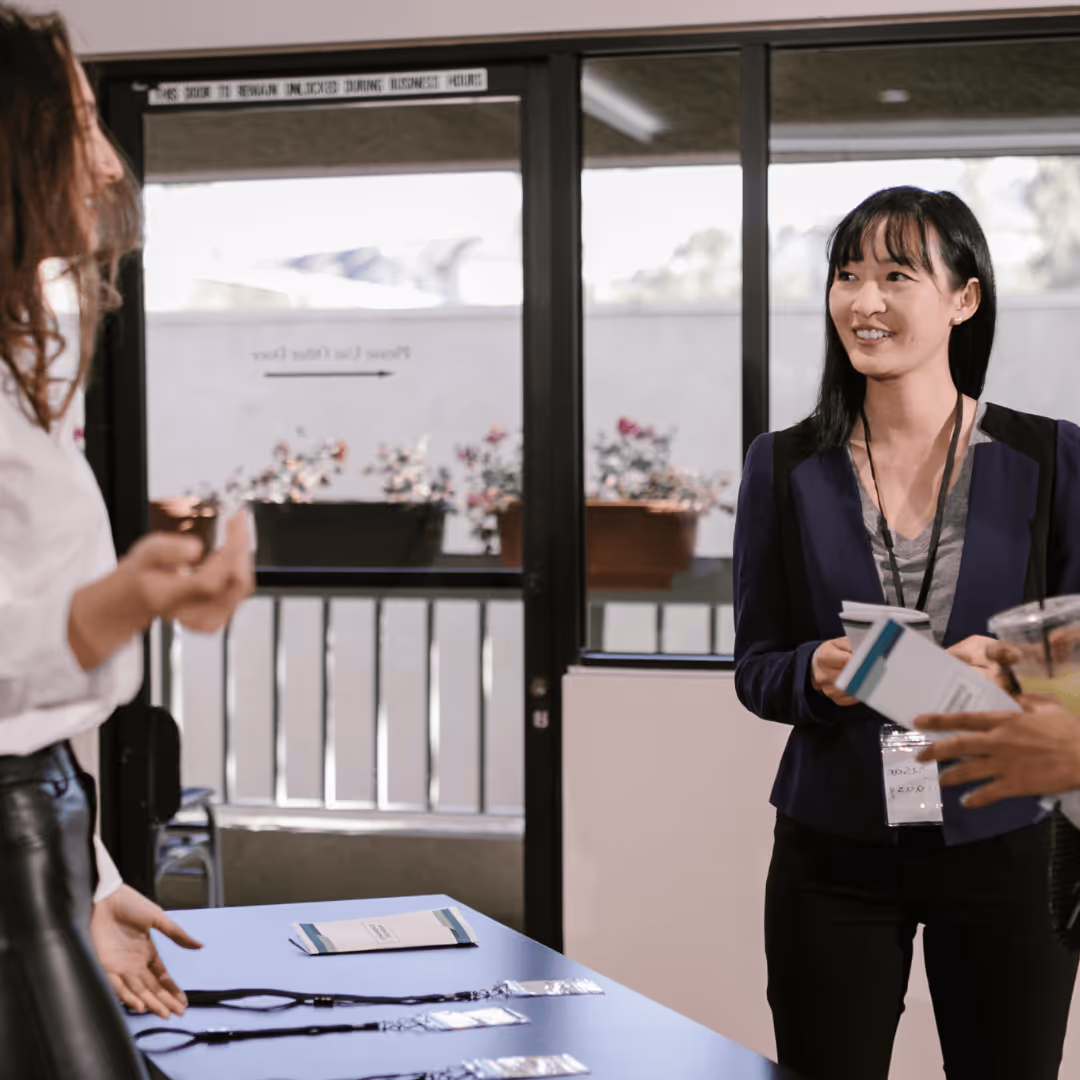 Woman smiling at person in line at an event table