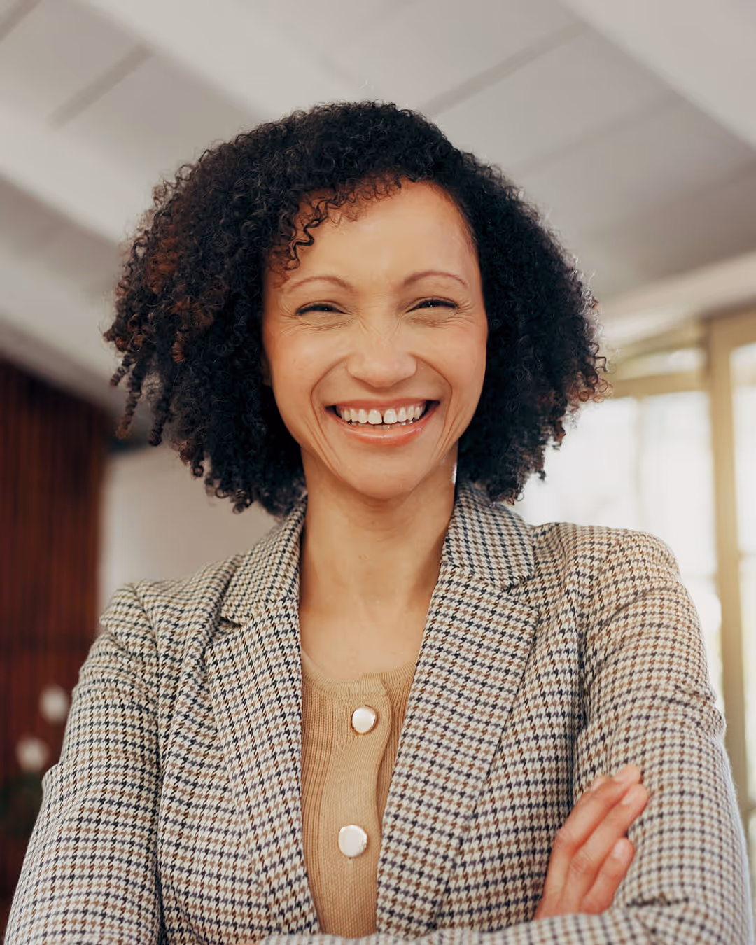 Woman at an event with a speaker pass on and holding a mic. 