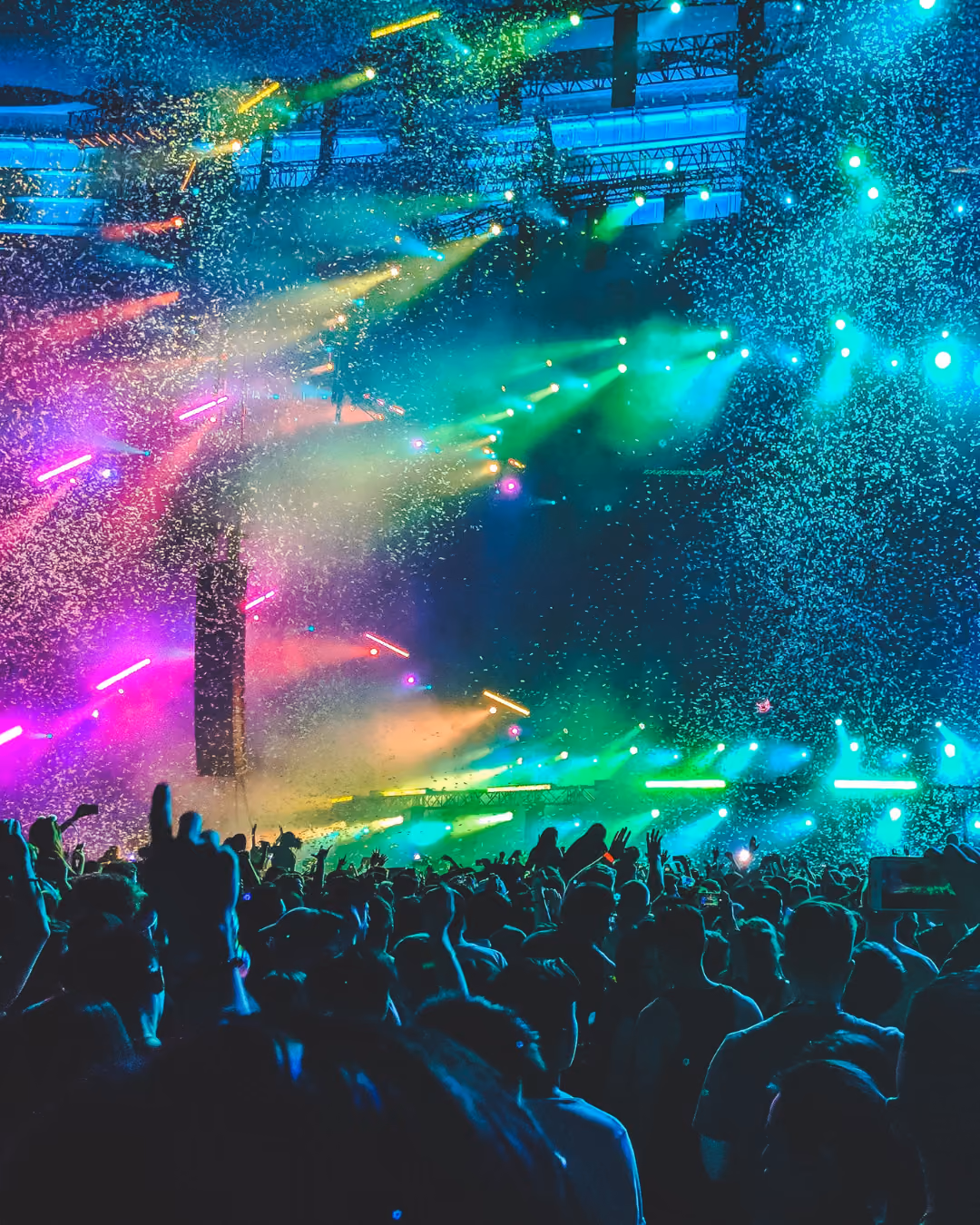 Event with confetti coming down and a crowd of hands in the air