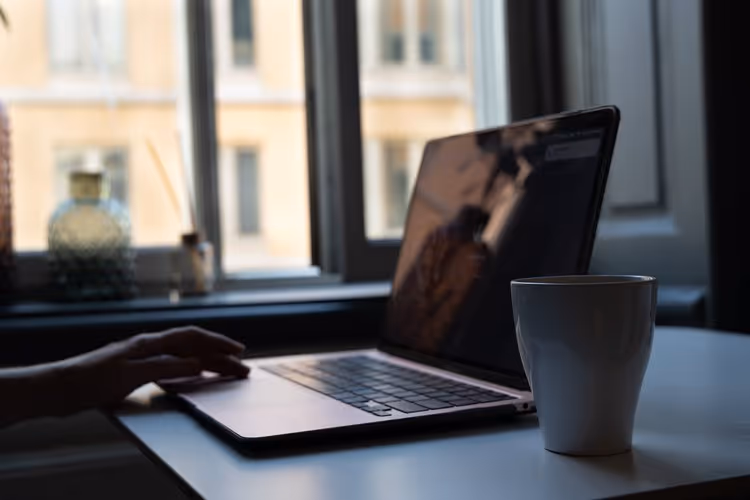 Working on a laptop in Sweden with a cup of tea sitting on the desk.