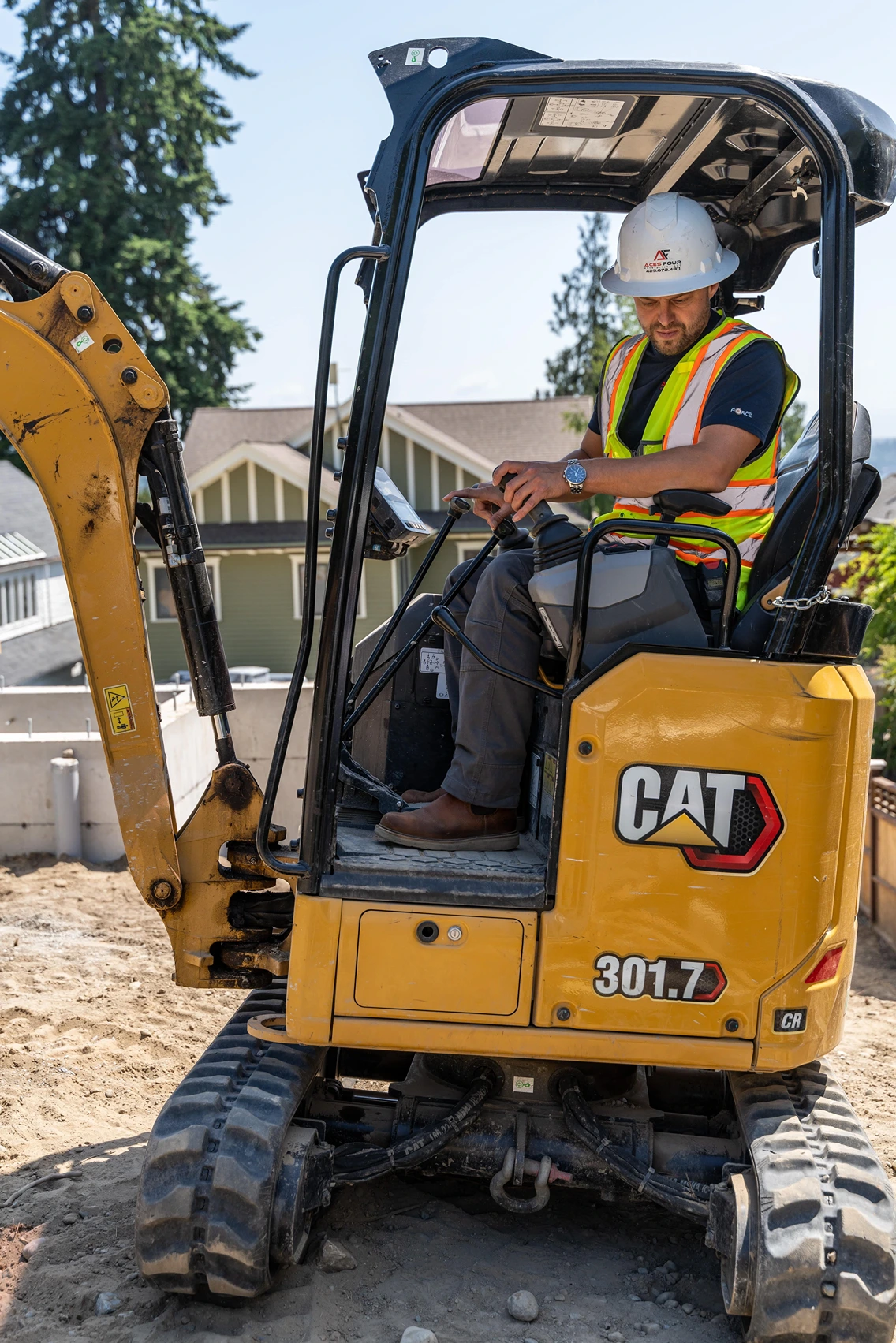 Skilled equipment operator maneuvering a Caterpillar mini excavator for Aces Four.