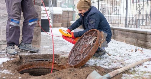 plumber unclogging blocked toilet with hydro jetting at home bathroom. sewer cleaning service