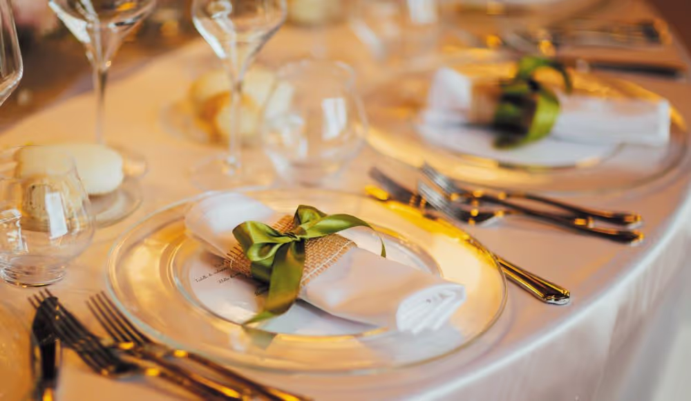 Table setting with white napkins and green bow