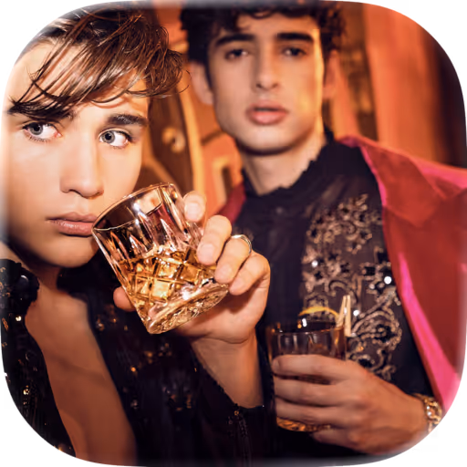 Zwei junge Männer in eleganter Kleidung, von denen einer nachdenklich einen Whisky im Glas hält.