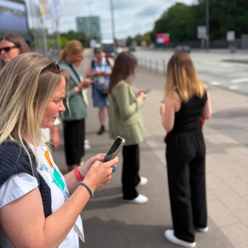 A group of people answer a Walkshop survey on their phones while they stand outside