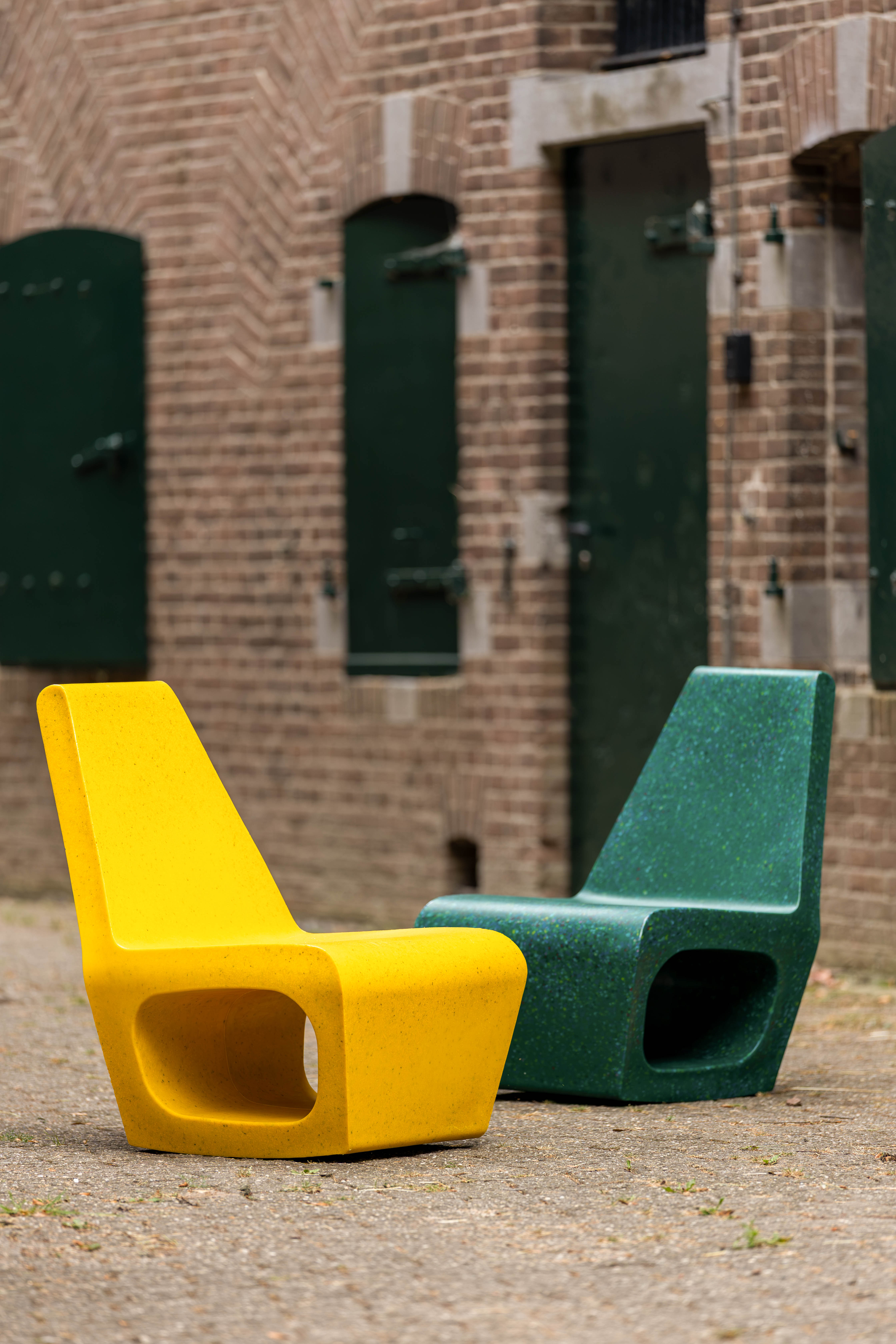 An image of designer Ineke Hans holding the chair as if it where to be recycled.
