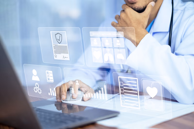 Arzt arbeitet am Laptop mit digitalen Gesundheits- und Datenanalyse-Symbolen im Vordergrund.