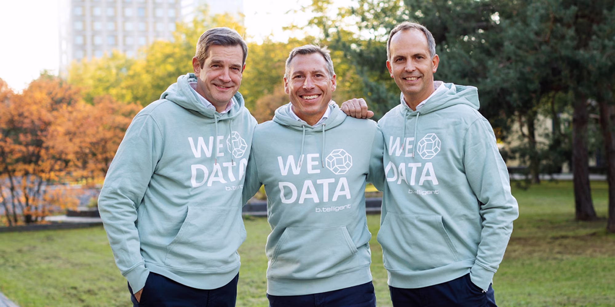 Geschäftsführer von b.telligent tragen Data Sweatshirts und lächeln.