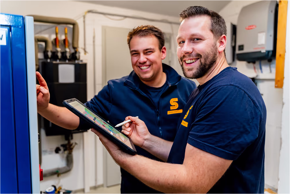 Zwei Handwerker mit Tablet bei der Reparatur einer Gastherme
