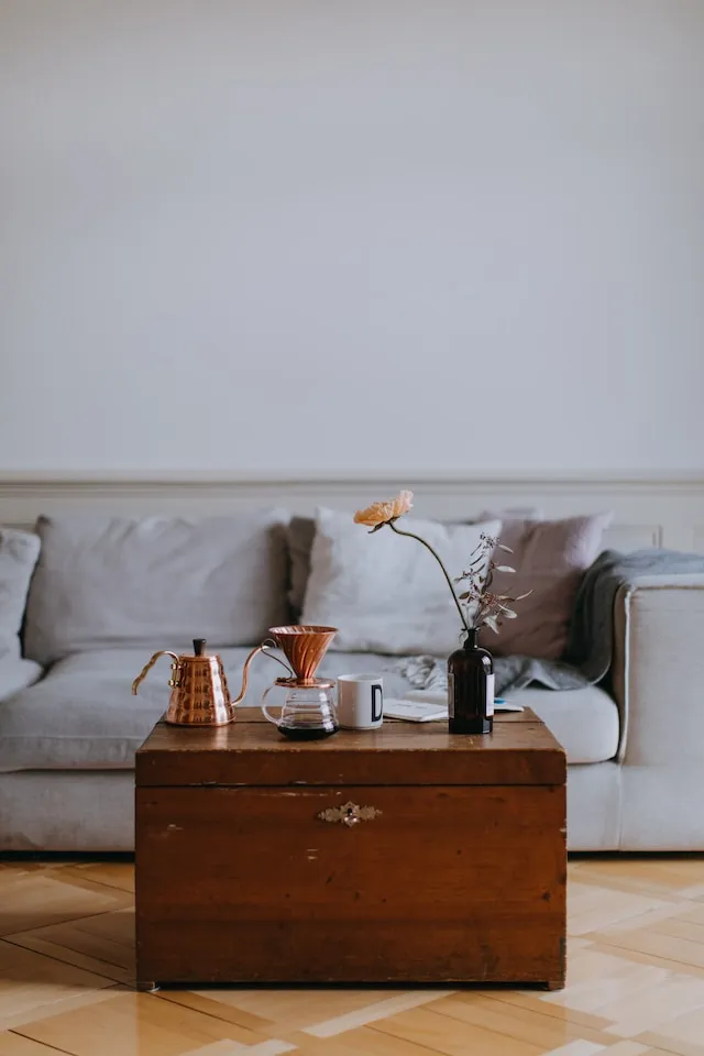 Teapot, coffee mug and a beautiful flower in the living room of a nice apartment