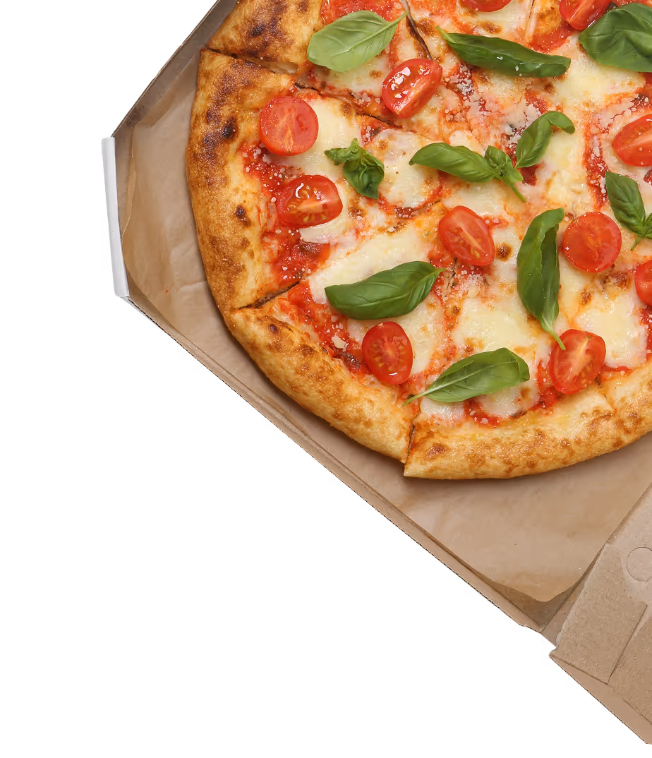 Pizza with tomato sauce, mozzarella, cherry tomatoes, and fresh basil leaves in a cardboard box.