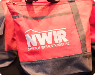 Red and gray tote bag with white text reading NWIR National Women in Roofing.