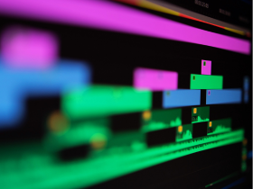 Colorful bars stretching across a computer screen, representing AI-assisted multi-track video editing or clipping.