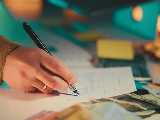 An image of a hand signing paperwork - how to write a standard roofing contract