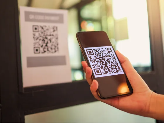A photo of a hand scanning a QR code on a door, leading to a roofer's Instant Estimator tool that can help qualify leads and win jobs.