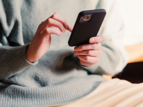 Photo of a homeowner on their smartphone, reading a marketing email from their local roofer.