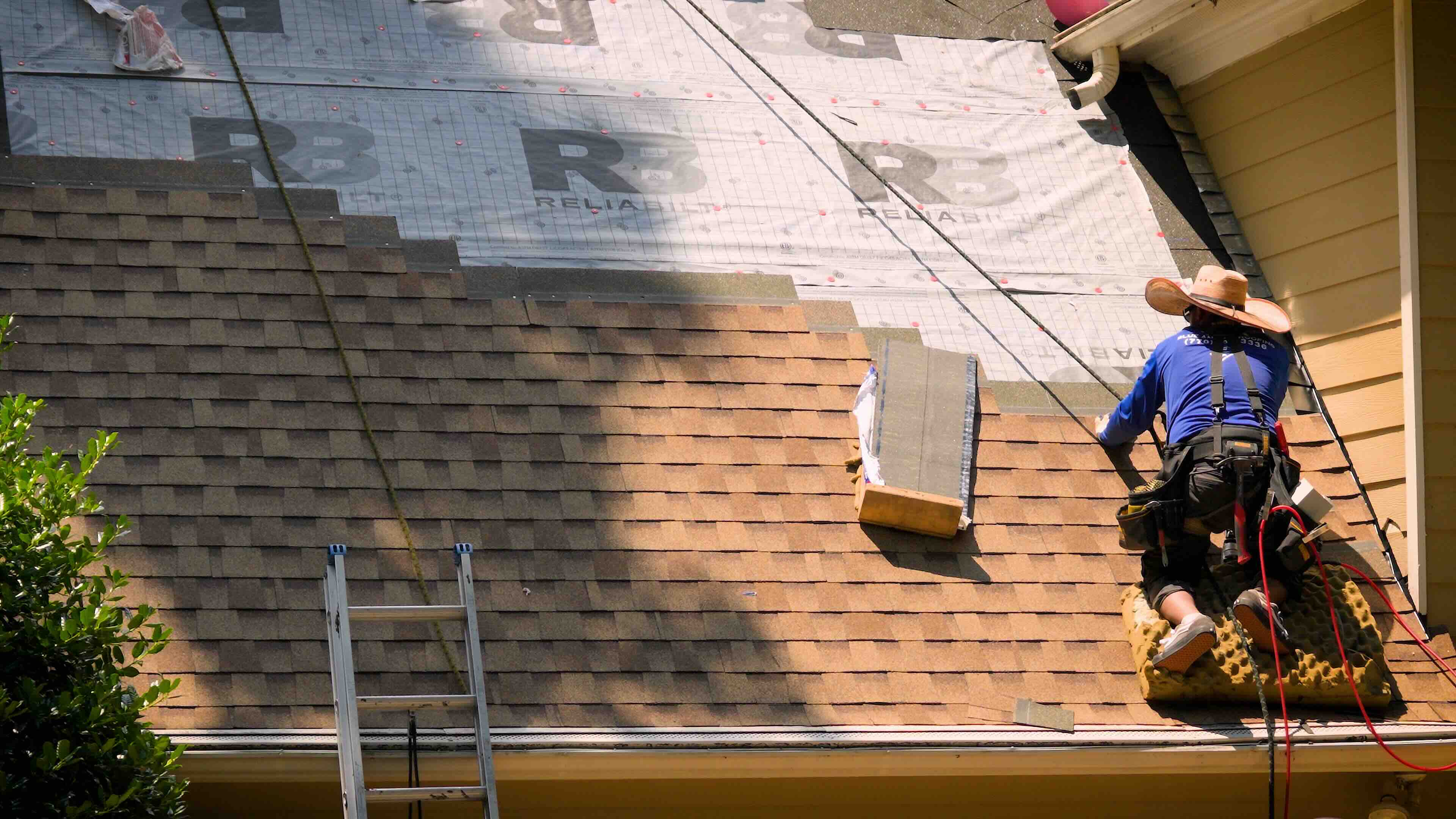 Man on a roof installing shingles