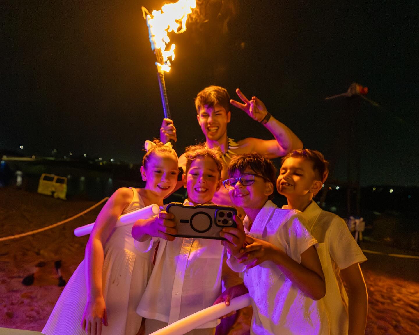 Luke Embers posing with fire with kids taking a selfie.
