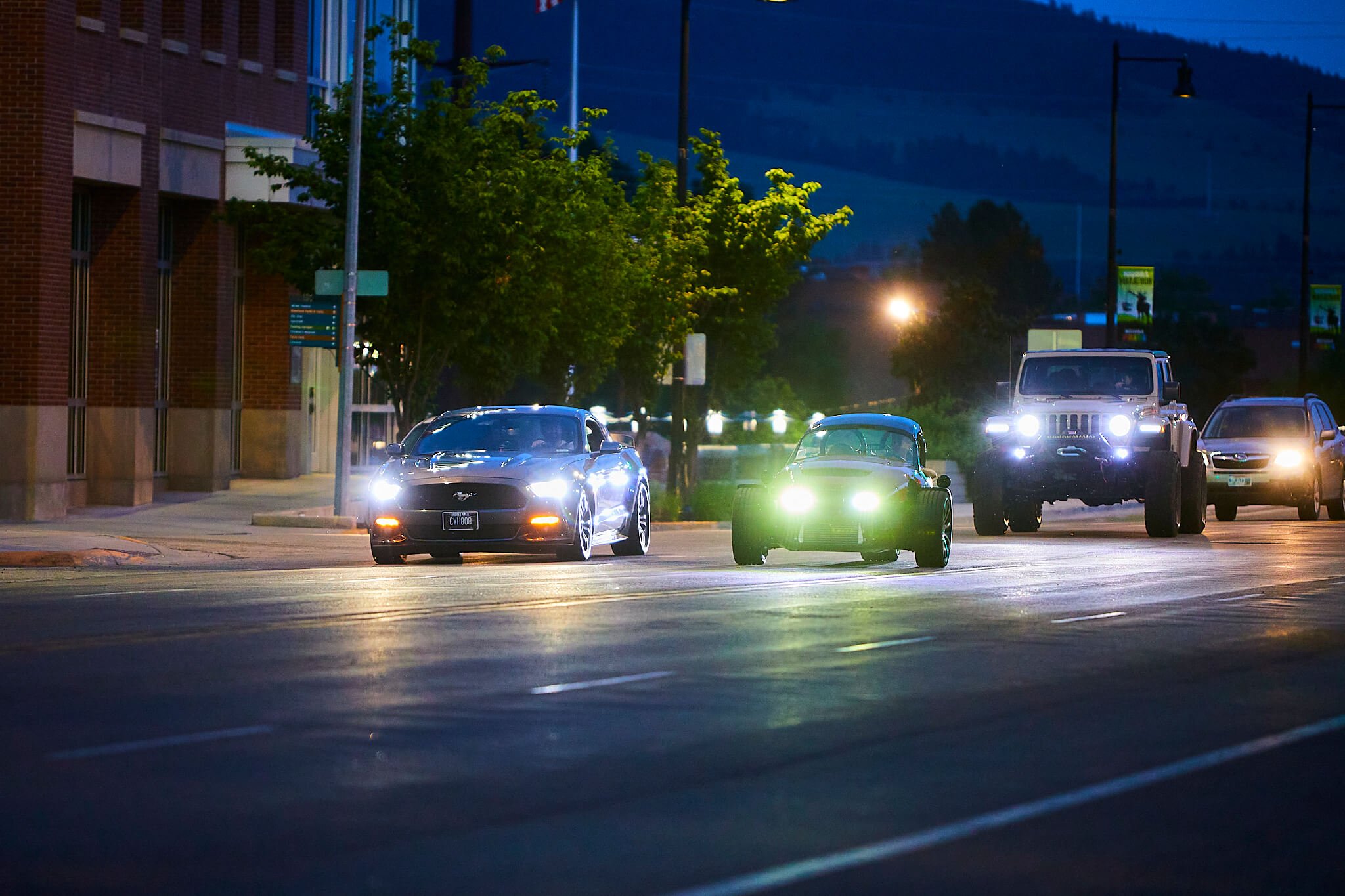 Vehicles from J&K Customs driving down the roads of Missoula at night.