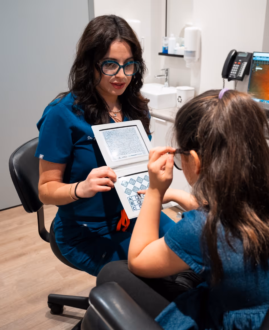 Dr. Joelle Zagury performing an eye exam on young patient.
