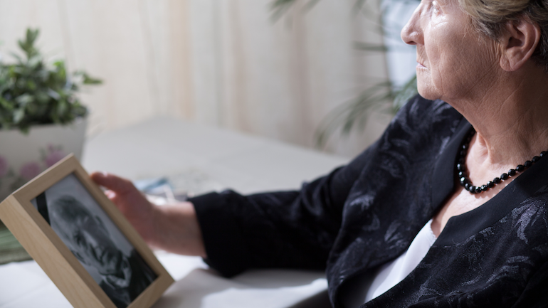 Woman looking at photo of deceased husband