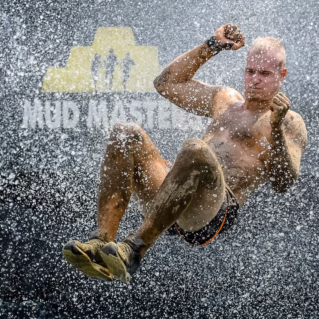 A participant soaring through cascading water droplets