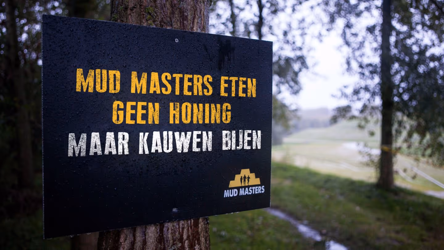 Een bord met de tekst: Mud Masters eten geen honing, ze kauwen bijen.
