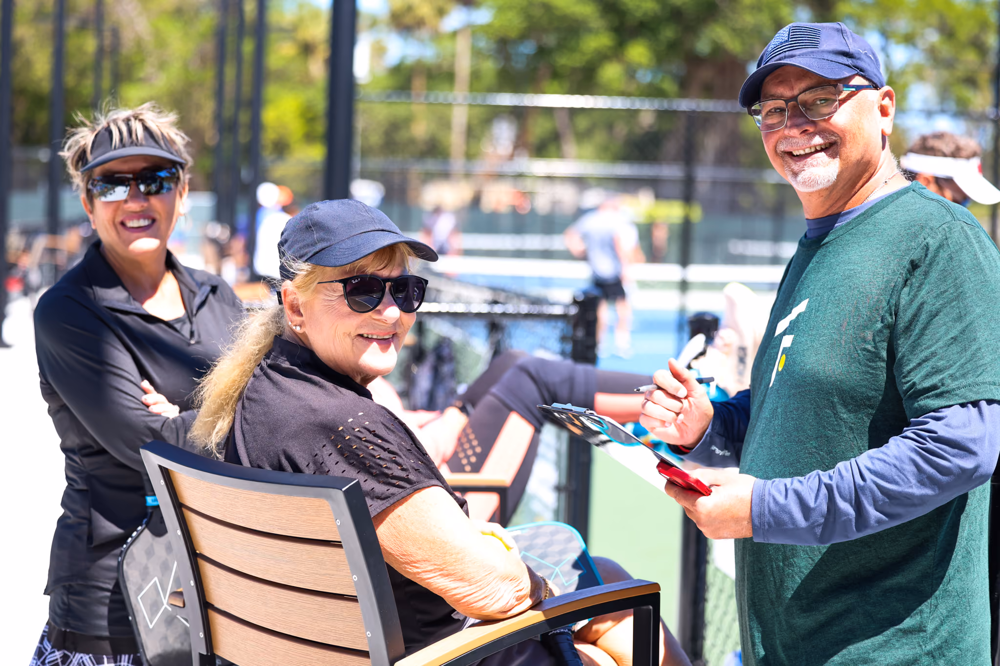 Pickleball players smiling together courtside after a session