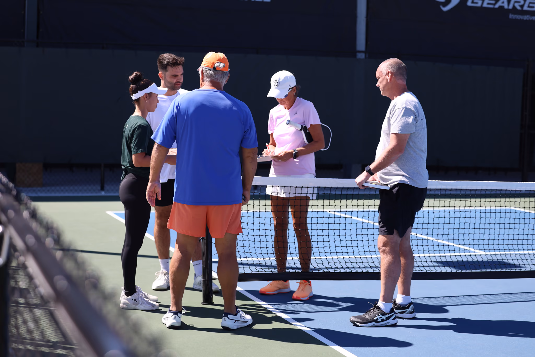 A DUPR Coach leading a group clinic on court