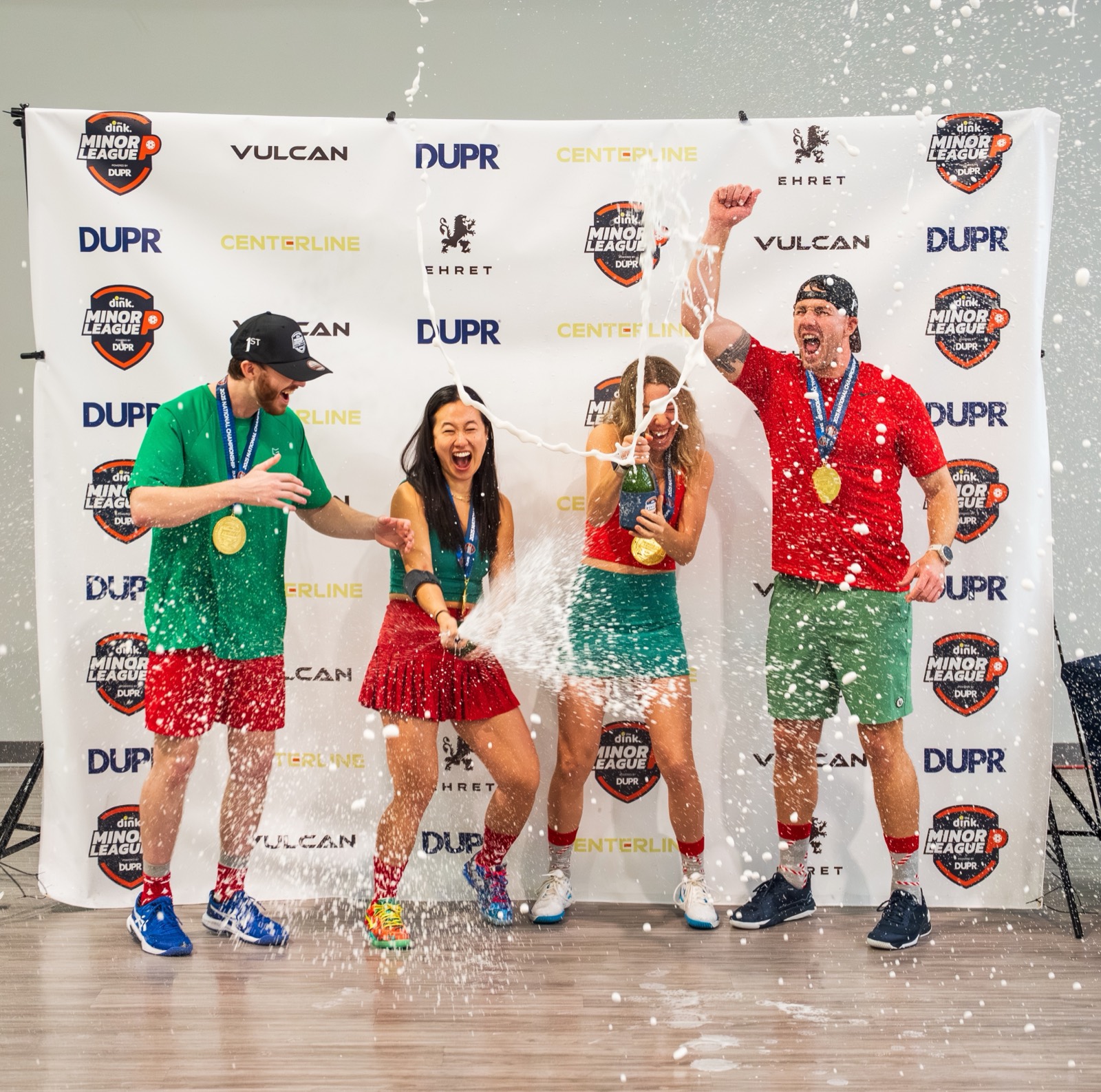 Minor League Pickleball champions spraying champagne with their medals at the National Championship