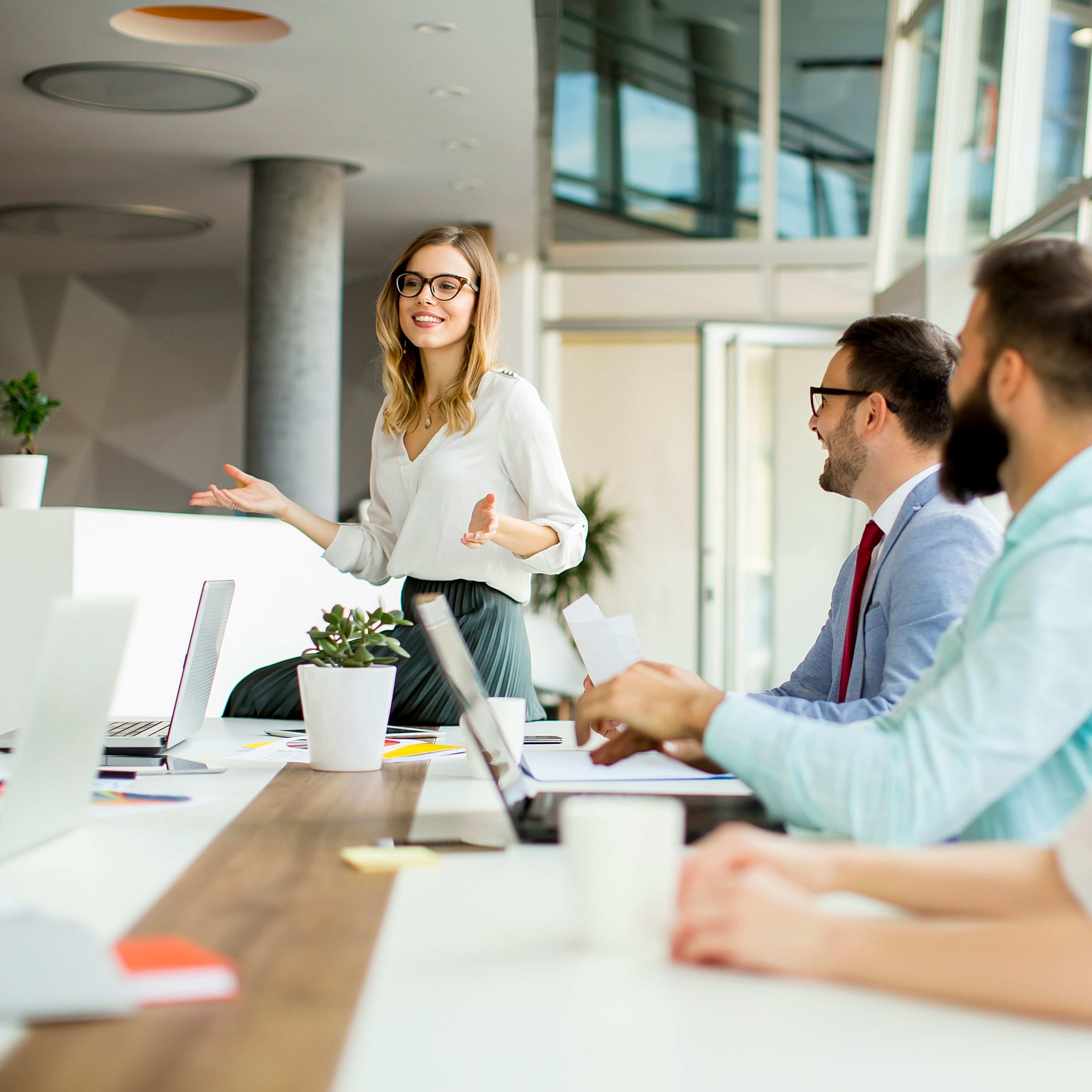 Junge Frau präsentiert im hellen Büro. Caona Health, Leadership in Digital Health, Innovation, Betriebliche Gesundheitsförderung. Gesundheit im Unternehmen. Mitarbeitergesundheit, Femtech.
