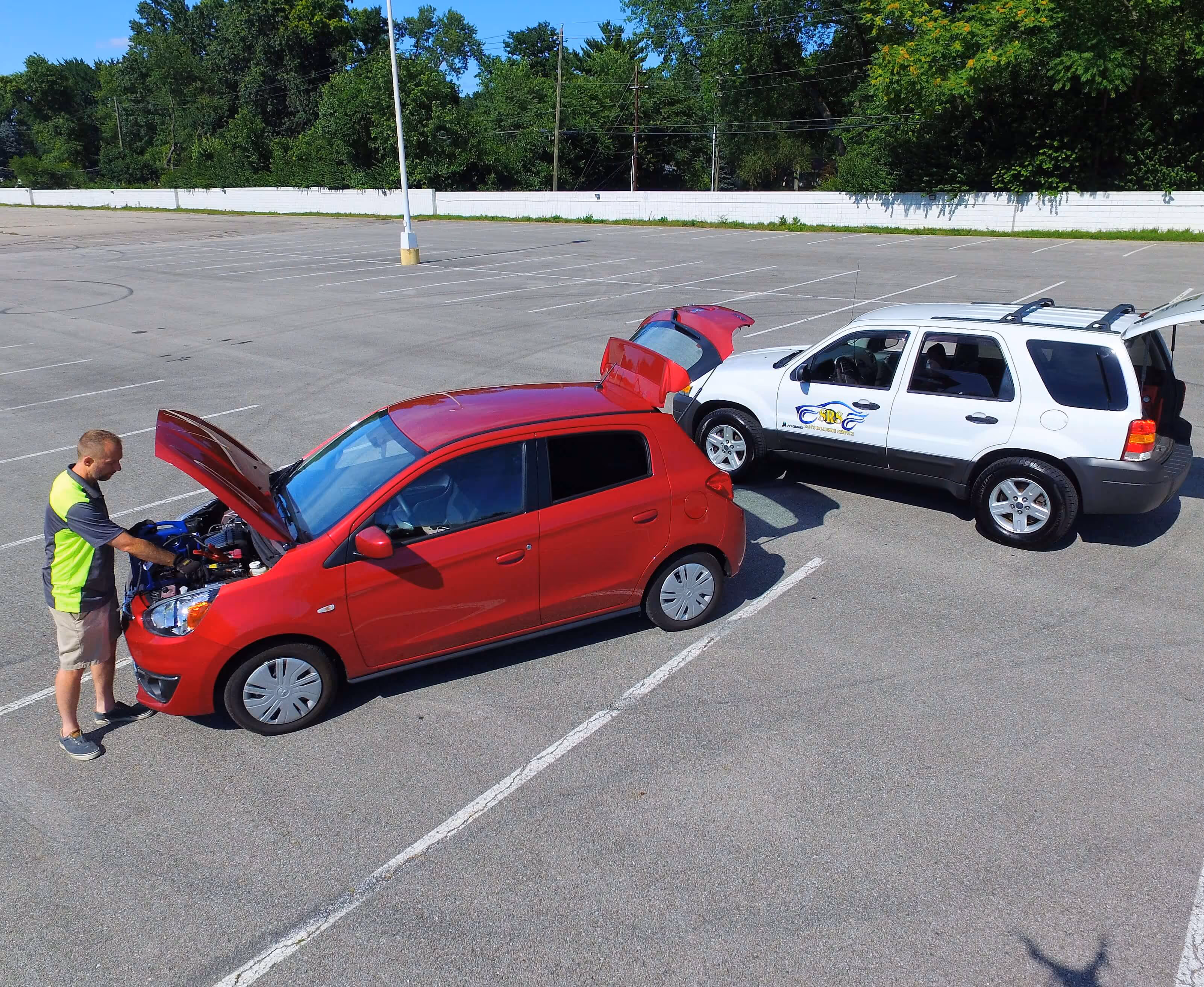Image of Sam assisting a customer with a jump start for a dead battery