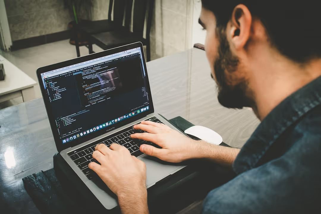 man typing on laptop