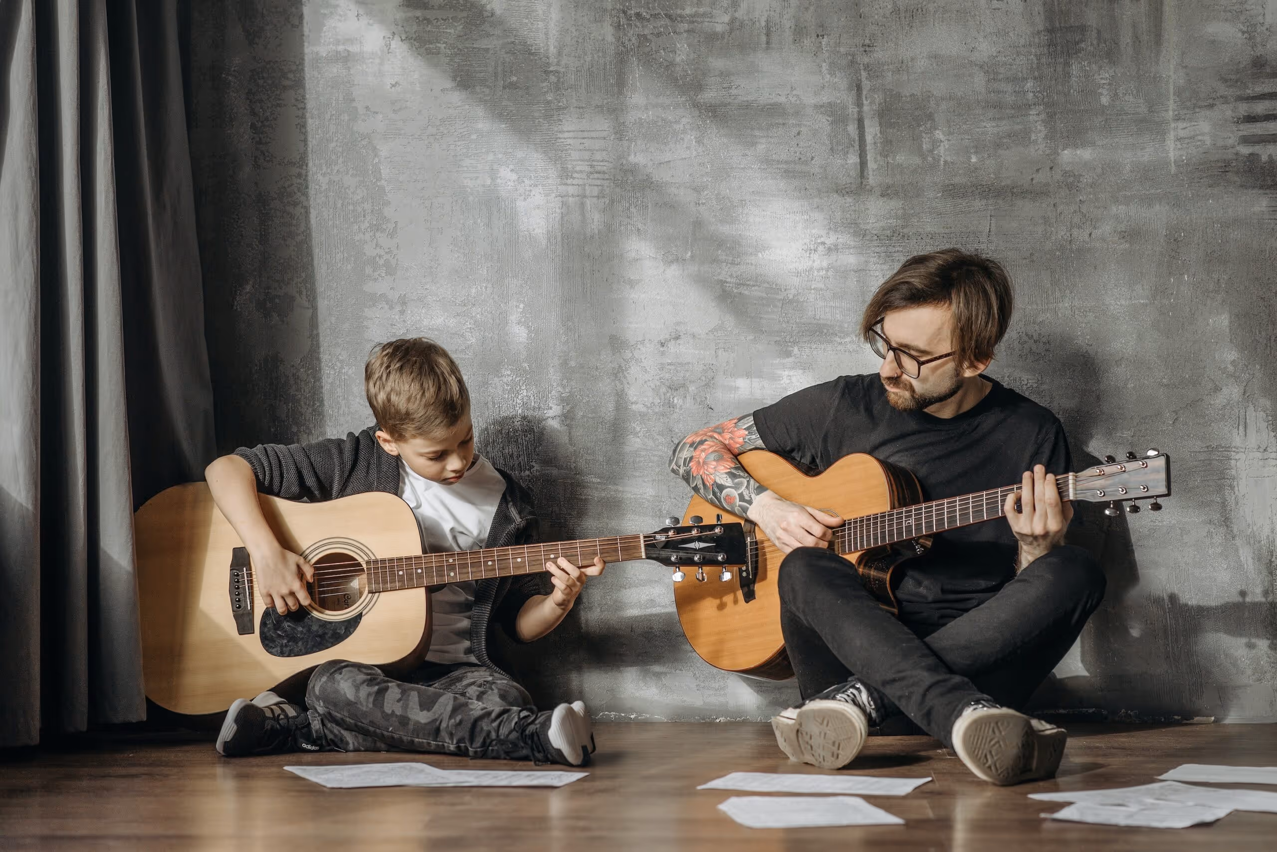 man teaching boy to play guitar