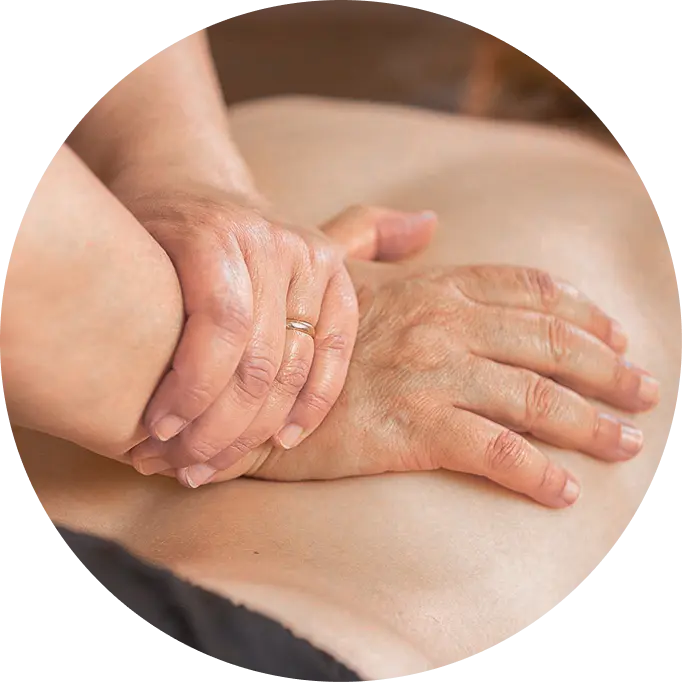 Close-up of hands giving a back massage on bare skin, with one hand pressing down and the other supporting the wrist.
