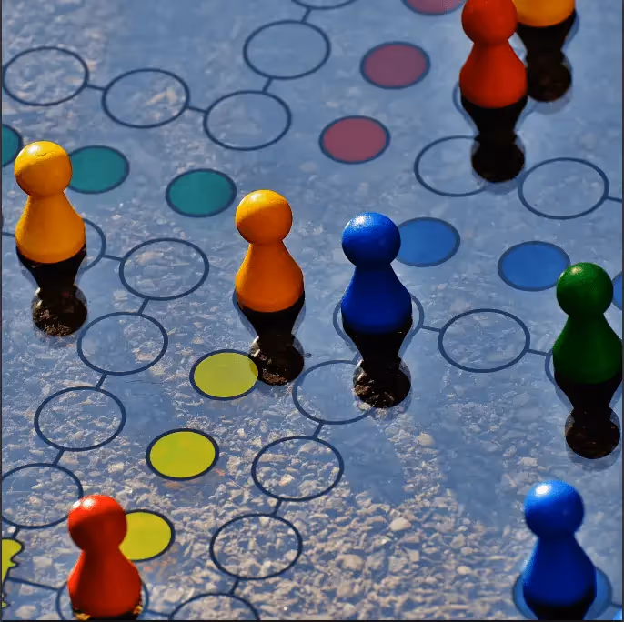 Colorful board game pieces on a game board, symbolizing BEE Pro tutorial on roles, permissions, and team collaboration.