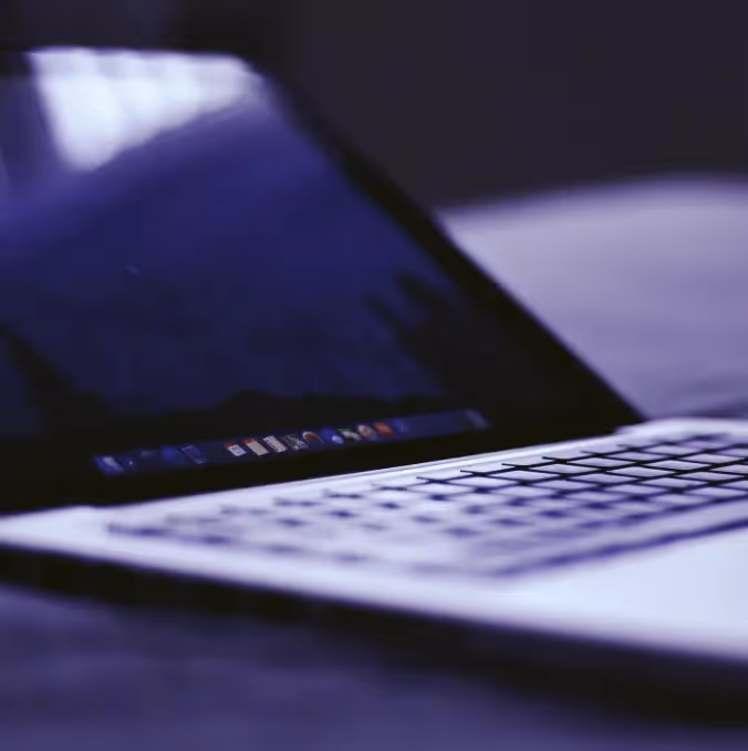 Close-up of laptop keyboard and dark screen with purple-blue lighting, symbolizing GDPR compliance email technology.