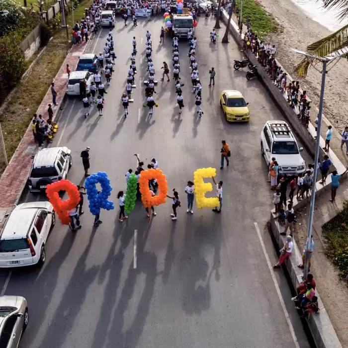 Pride Month email invitation with rainbow peace sign and colorful balloon parade spelling “PRIDE,” celebrating love, inclusivity, and diversity.