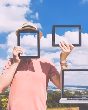 Creative photo of person holding tablets and laptop showing sky and clouds, symbolizing responsive tablet-friendly email design concepts.