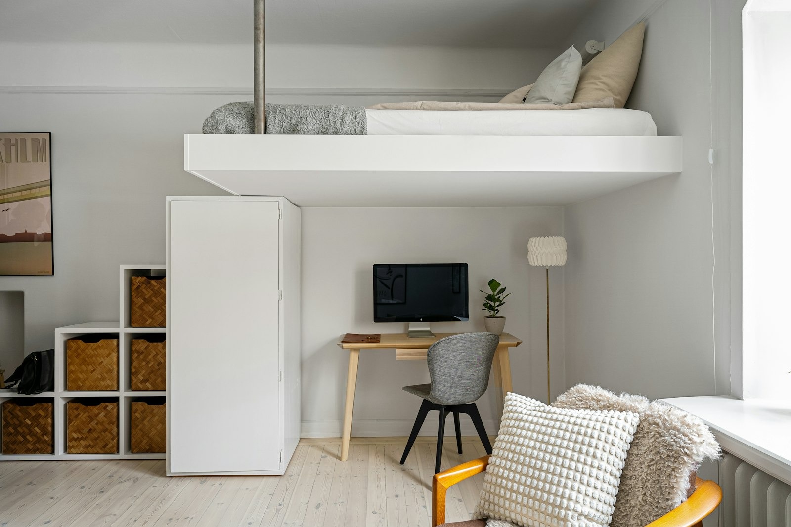 Kamar dengan tempat tidur loteng dan meja kerja di bawahnya, contoh ruang multifungsi di apartemen kecil